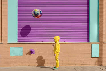 Kleines Mädchen in gelb gekleidet mit Luftballon - ERRF03183