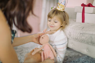 Nahaufnahme von Mutter Giving Spielzeug zu niedlichen Mädchen zu Hause - EYF03640