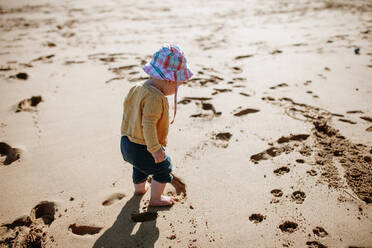 Full Length Of Baby Girl Standing At Sandy Beach On Sunny Day - EYF03696