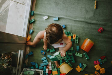 Direkt über Schuss von Baby Mädchen spielen mit Spielzeug zu Hause - EYF03733