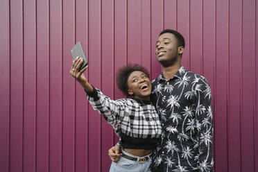 Portrait of young couple taking selfie with smartphone - AHSF02204