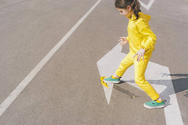 Girl stepping on banana peel on a street - ERRF03210