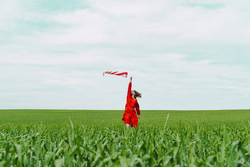 Frau in rotem Kleid hält Windsack auf einem Feld - ERRF03227