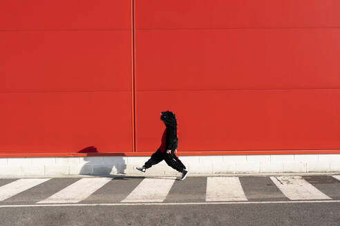 Little girl wearing black fancy dress walking on zebra crossing - ERRF03272