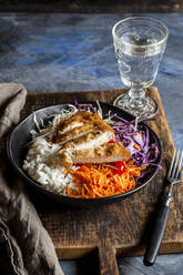 Bowl of ready-to-eat salad with white and red cabbage, carrots, rice and chicken schnitzel - SBDF04239