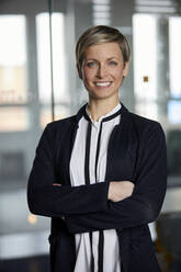 Portrait of smiling businesswoman in office - RBF07375