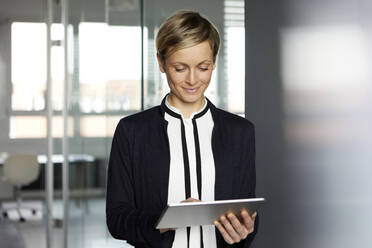 Businesswoman using tablet in office - RBF07377