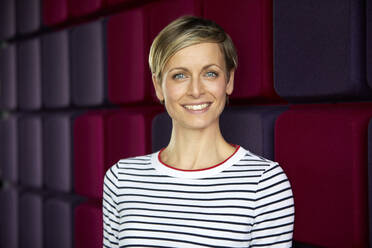 Portrait of a smiling woman at a purple wall - RBF07395