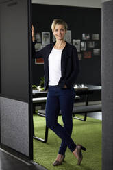 Portrait of smiling businesswoman in office - RBF07402
