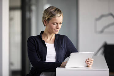 Businesswoman using tablet in office - RBF07410