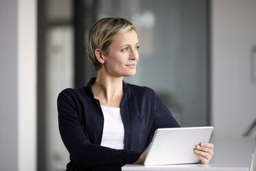 Smiling businesswoman using tablet in office - RBF07411