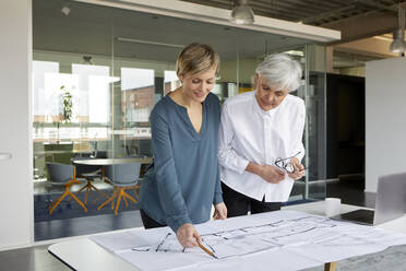 Zwei Geschäftsfrauen arbeiten gemeinsam an einem Bauprojekt im Büro - RBF07414