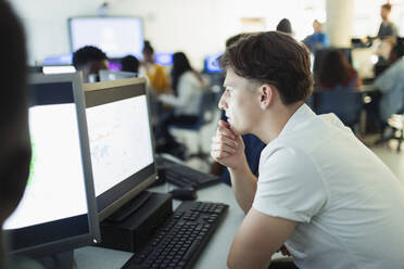 Focused junior high boy student using computer in computer lab - CAIF25709