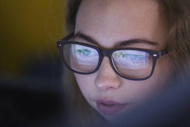 Close up fokussiert Teenager-Mädchen mit Brille Blick auf Gerät Bildschirm - CAIF25715