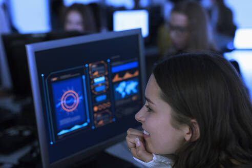 Lächelnde Schülerin der Junior High, die einen Computer im Computerraum benutzt - CAIF25726