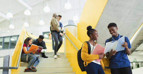 Schüler der Sekundarstufe II unterhalten sich und lernen auf einer Treppe - CAIF25734