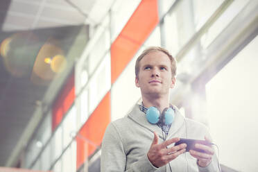 Pensive young man with headphones and mp3 player - CAIF25772