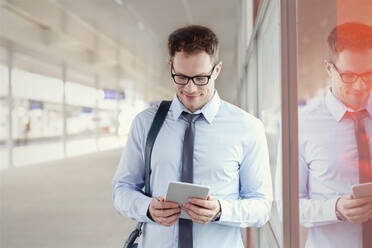 Geschäftsmann mit digitalem Tablet im Bahnhof - CAIF25779