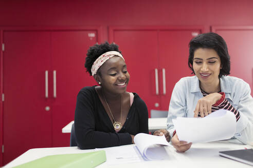 Studentinnen einer Volkshochschule diskutieren über Papierkram im Klassenzimmer - CAIF25812