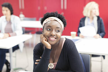 Smiling, confident young female community college student in classroom - CAIF25834