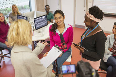 Community college journalism students at microphone in classroom - CAIF25856