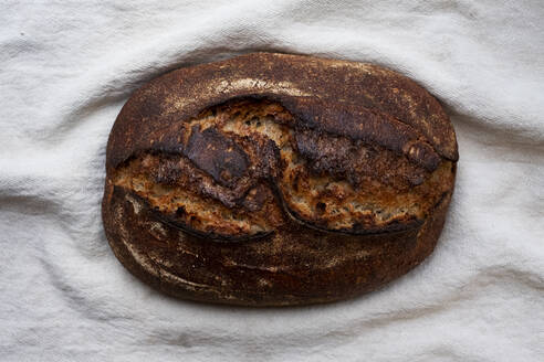 Nahaufnahme eines frisch gebackenen Brotlaibs in einer handwerklichen Bäckerei. - MINF14536