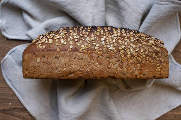 Nahaufnahme eines frisch gebackenen Brotes mit Samen in einer handwerklichen Bäckerei. - MINF14540