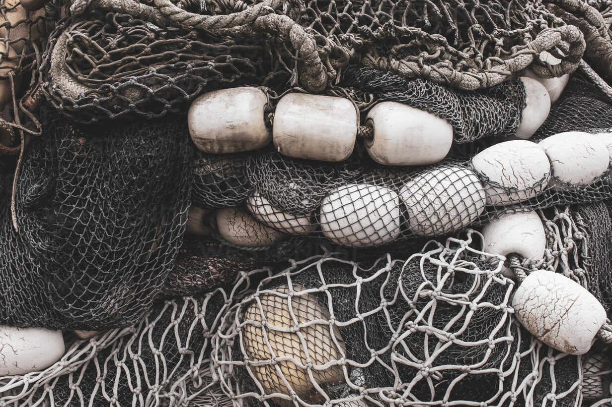 Pile of commercial fishing nets and gill nets on a fishing quay. stock photo