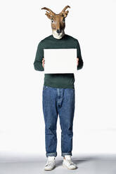 Mann mit Rentiermaske hält leeres Schild - FSIF04634
