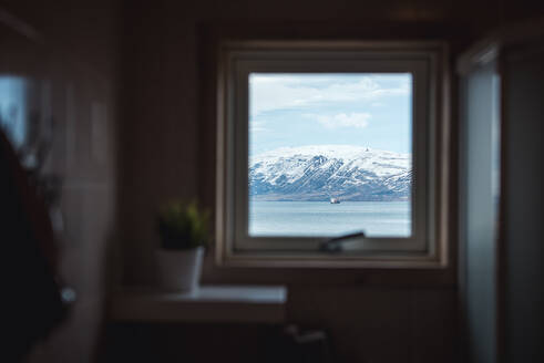 Blick durch ein Hausfenster auf ein Boot in Akureyri, Island - CAVF77999