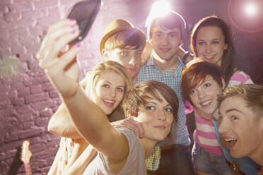 Happy teenage friends taking selfie at party - FSIF04638