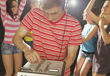 Teenage boy DJ playing music at party - FSIF04651
