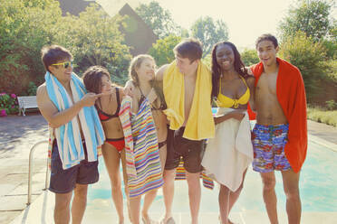 Portrait happy teenage friends at sunny summer poolside - FSIF04659