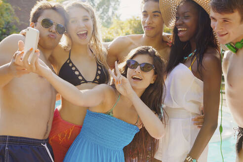 Glückliche Teenager-Freunde, die ein Selfie mit einem Smartphone auf einer sonnigen Sommerterrasse machen - FSIF04663