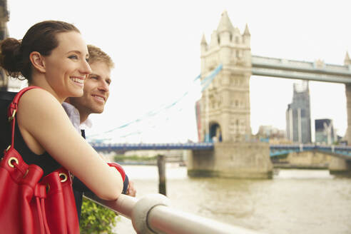 Glückliches junges Paar genießt den Blick auf die Themse und die Tower Bridge, London - FSIF04692