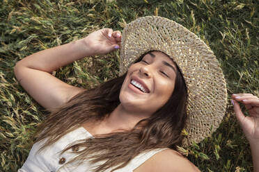 Pretty Latina woman laughing in the grass - CAVF78043