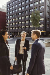 Lächelnde männliche und weibliche Unternehmer, die im Freien stehen - MASF17619