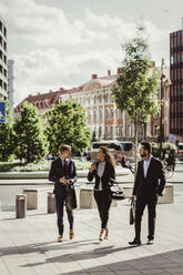 Unternehmerin bespricht Strategie mit männlichen Kollegen beim Spaziergang im Freien - MASF17629