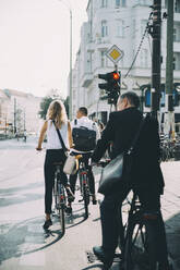 Geschäftsleute in voller Länge beim Fahrradfahren auf der Straße in der Stadt - MASF17856