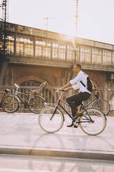 Geschäftsmann in voller Länge auf dem Fahrrad auf der Straße in der Stadt gegen den Himmel - MASF17873