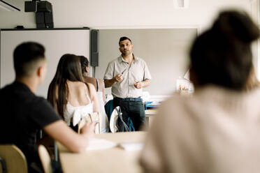 Professor unterrichtet, während Teenager im Klassenzimmer sitzen - MASF17875