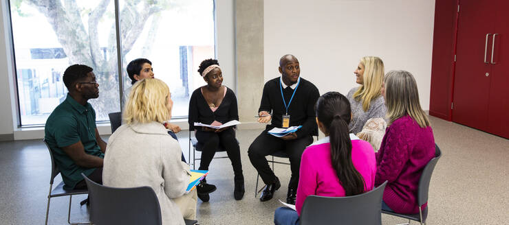 People talking in support group meeting circle in community center - CAIF25935