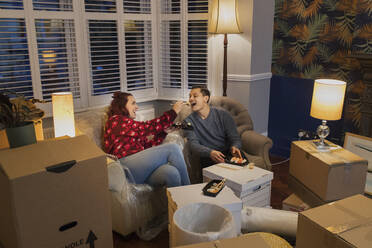 Couple taking a break from moving, eating sushi - CAIF25946