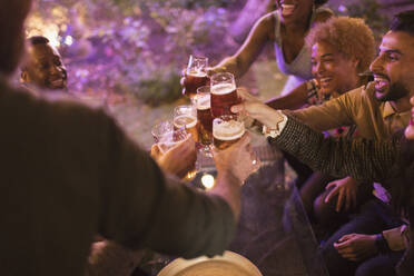 Friends toasting beer glasses at garden party - CAIF26000