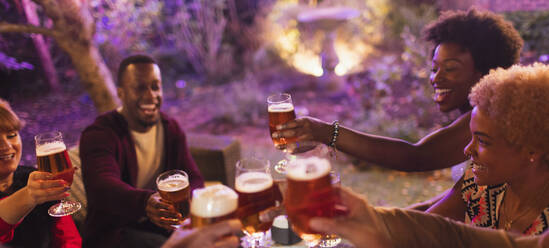 Friends toasting beer glasses at party - CAIF26018