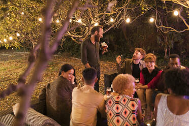 Freunde reden und trinken auf einer Gartenparty - CAIF26025