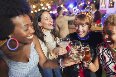 Glückliche Freundinnen stoßen auf einer Party mit Cocktails an - CAIF26032