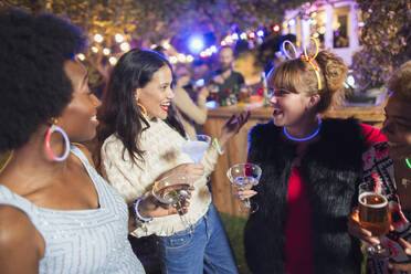 Glückliche Freundinnen trinken Cocktails auf einer Party - CAIF26037
