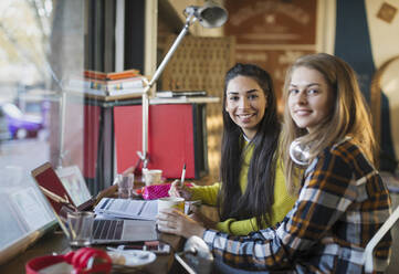 Porträt lächelnd Studentinnen studieren am Laptop im Café - CAIF26045