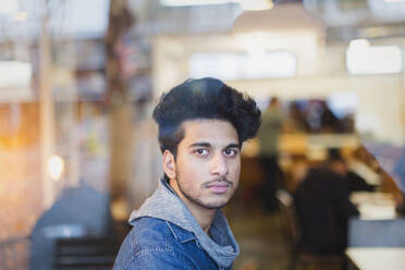 Porträt selbstbewusster junger Mann im Fenster eines Cafés - CAIF26050